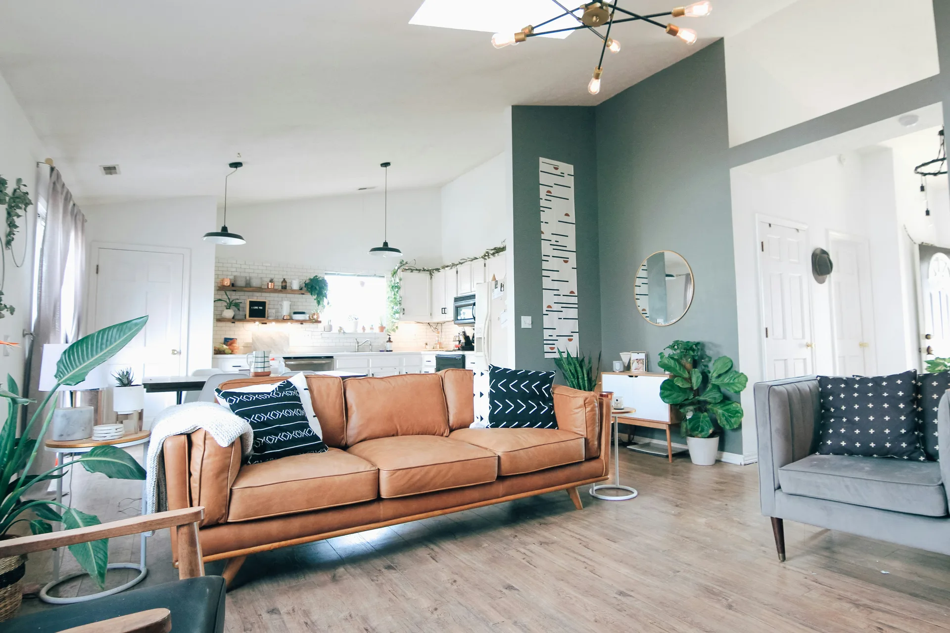 A papered interior wall styled with a shelf and home accessories in natural daylight