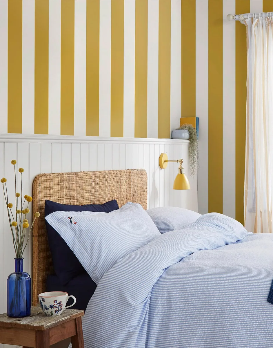 Harborough Stripe wallpaper by Joules, a soft multicoloured ticking stripe, shown on a room wall