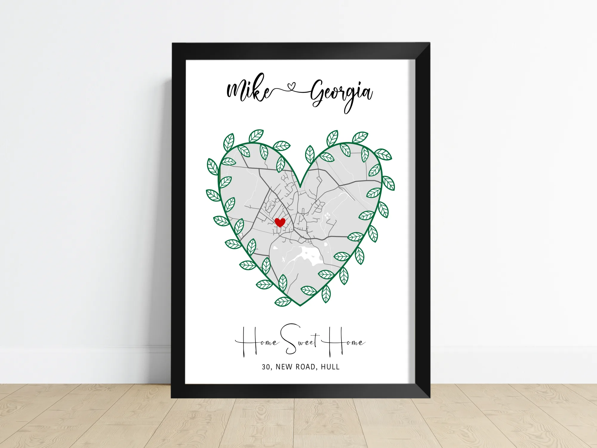 A personalised house map print shaped into a heart with a green leaf border